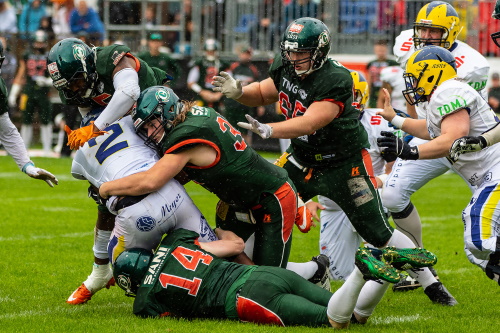 Darin Hungerford (5), Lucas Biere (32) und Christian Baumann (14) tackeln Phillip Gamble