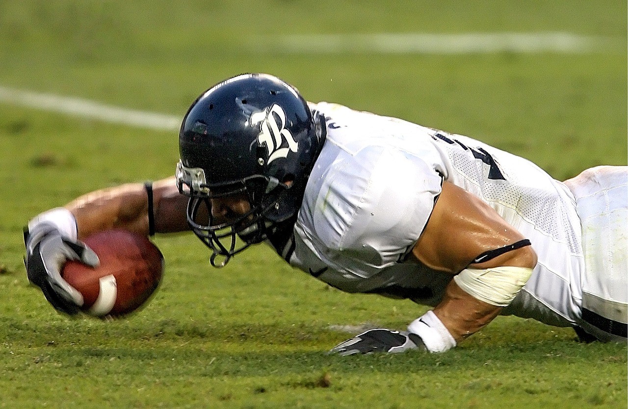 Spieler greift beim American Football nach dem Ball
