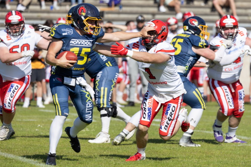 QB Marvin Neese (15) hält sich den Verteidiger mit einem Stiff Arm vom Leib